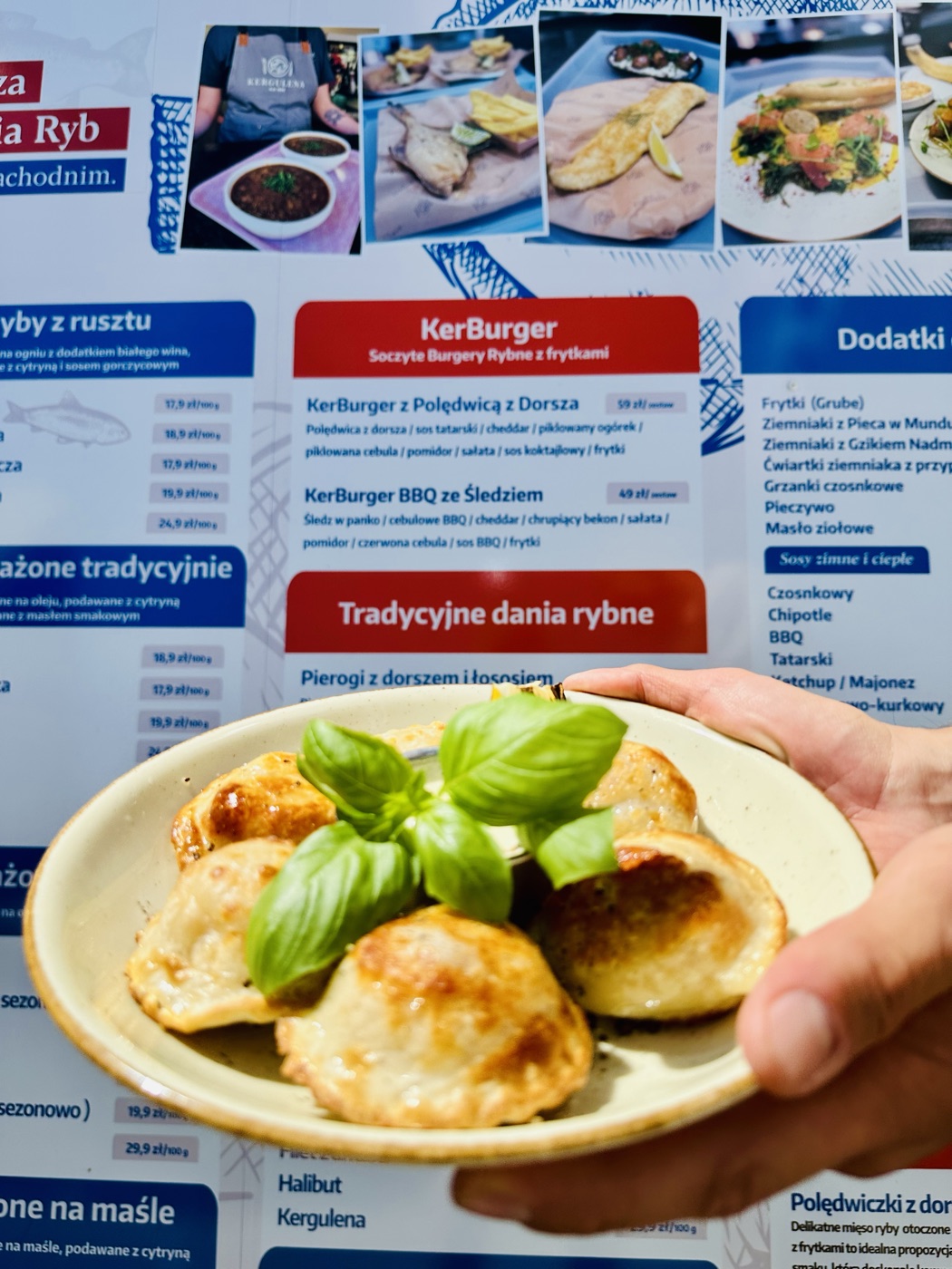 Pierogi z dorszem i łososiem — smażone na złoto, przybrane świeżą bazylią, podawane na talerzu